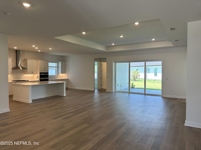 206 Holly Ridge Way, Saint Augustine, FL 32092 - unfurnished living room featuring baseboards, a raised ceiling, dark wood-style floors, and recessed lighting