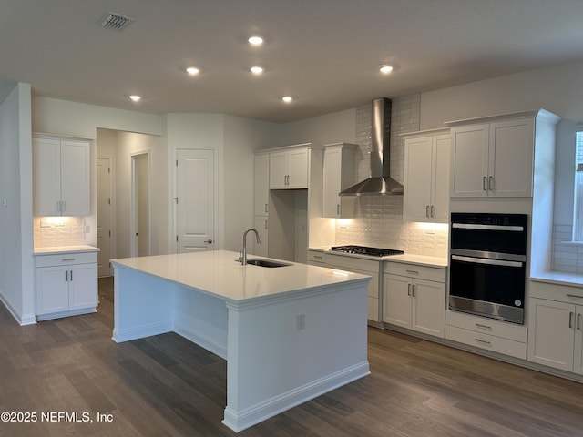 206 Holly Ridge Way, Saint Augustine, FL 32092 - kitchen with wall chimney exhaust hood, a sink, appliances with stainless steel finishes, dark wood-style flooring, and tasteful backsplash