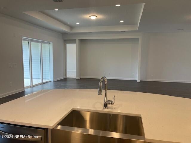 kitchen featuring sink and a tray ceiling