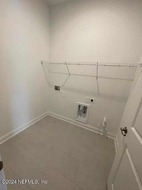 clothes washing area with tile patterned floors, electric dryer hookup, and hookup for a washing machine