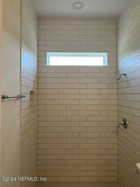 bathroom featuring a tile shower and plenty of natural light