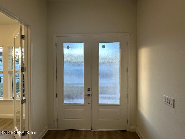 entryway with dark hardwood / wood-style flooring and french doors