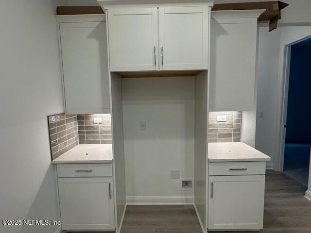 kitchen with backsplash, dark hardwood / wood-style floors, and white cabinets