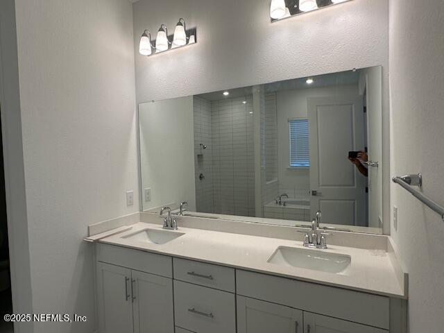 bathroom with vanity and independent shower and bath