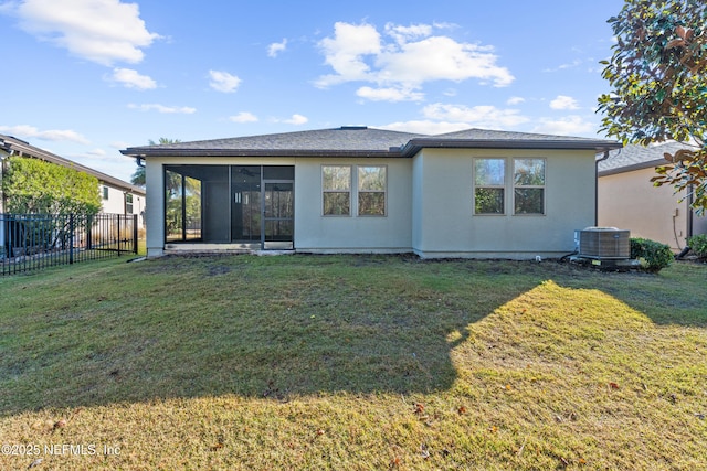 rear view of house with central AC unit, a lawn, and a sunroom