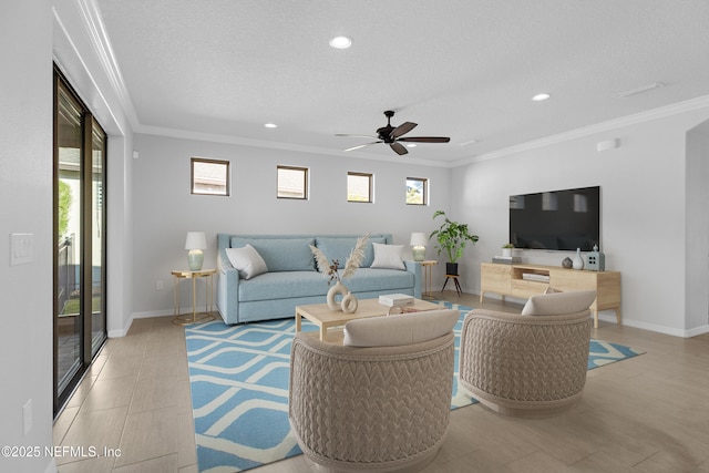 living room featuring a textured ceiling, ceiling fan, and crown molding