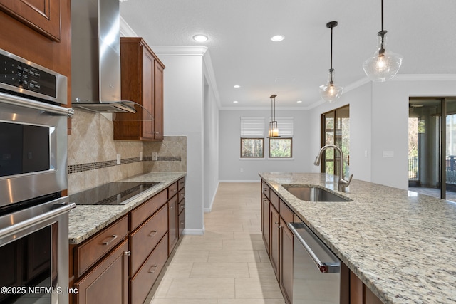 kitchen with light stone countertops, appliances with stainless steel finishes, wall chimney exhaust hood, and sink