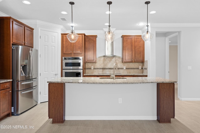 kitchen featuring light stone countertops, pendant lighting, appliances with stainless steel finishes, sink, and a center island with sink