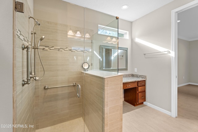 bathroom with a shower with shower door, vanity, and tile patterned flooring