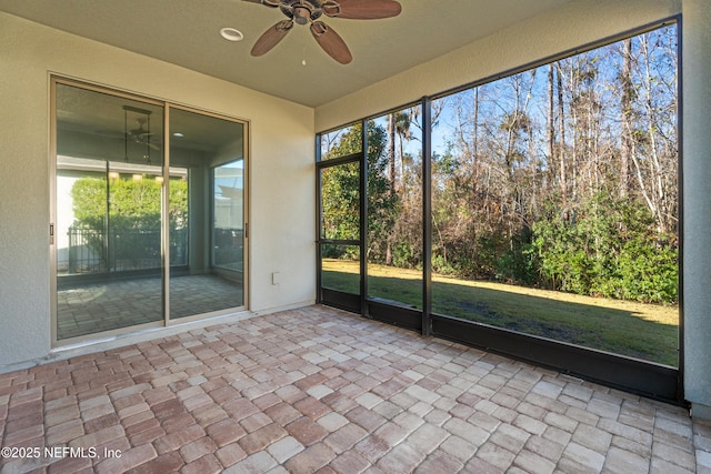 unfurnished sunroom with ceiling fan