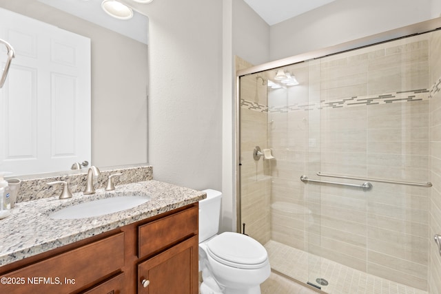 bathroom with a shower with door, toilet, and vanity