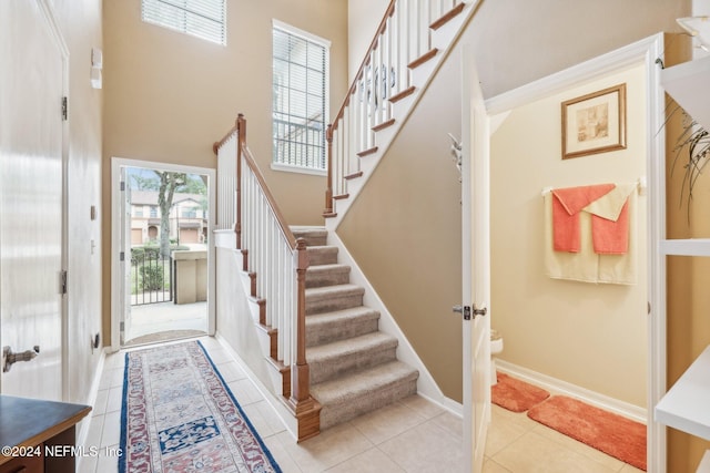 foyer featuring light tile patterned flooring and a high ceiling