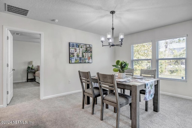 carpeted dining space featuring an inviting chandelier and a textured ceiling