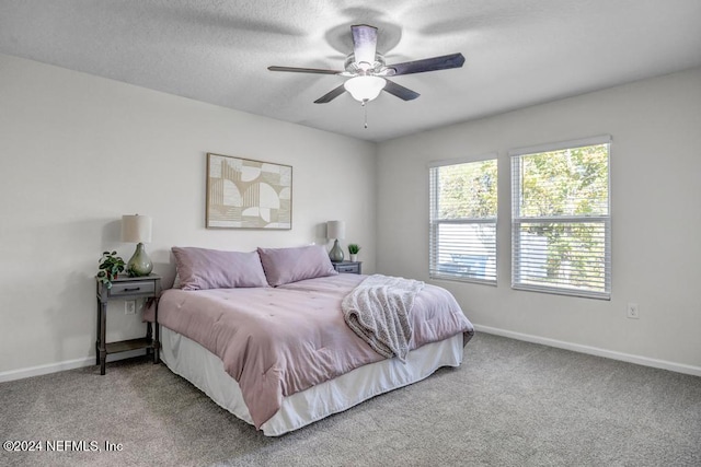 carpeted bedroom with a textured ceiling and ceiling fan