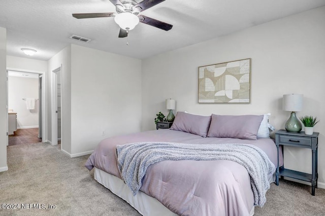 carpeted bedroom featuring connected bathroom and ceiling fan