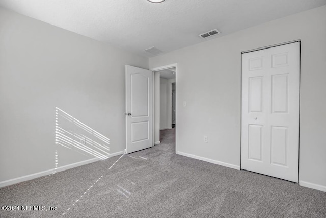 unfurnished bedroom with a closet and carpet floors