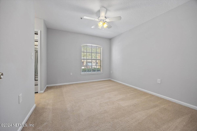 carpeted spare room featuring ceiling fan and a textured ceiling