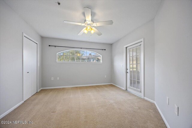 empty room featuring light colored carpet and ceiling fan