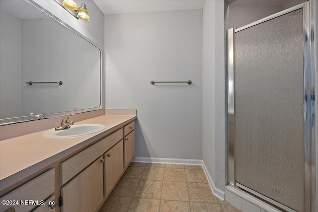 bathroom with vanity and a shower with door