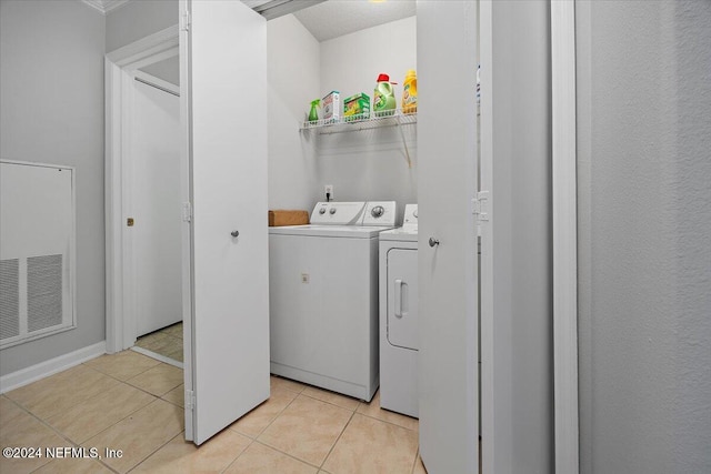 washroom with washer and clothes dryer and light tile patterned floors