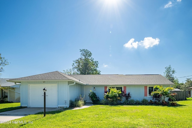 ranch-style home with a garage and a front lawn