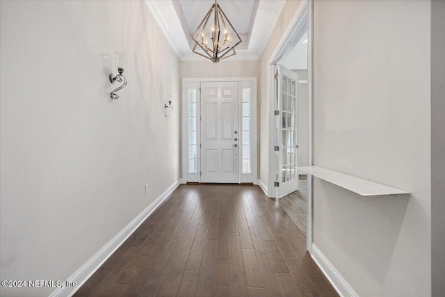 foyer featuring crown molding, dark hardwood / wood-style flooring, and an inviting chandelier