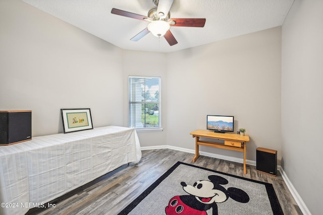 bedroom with a textured ceiling, hardwood / wood-style flooring, and ceiling fan