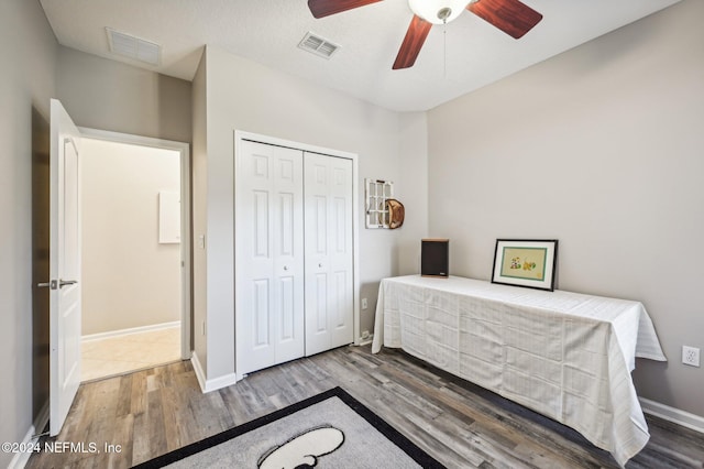 bedroom featuring a closet, hardwood / wood-style floors, a textured ceiling, and ceiling fan