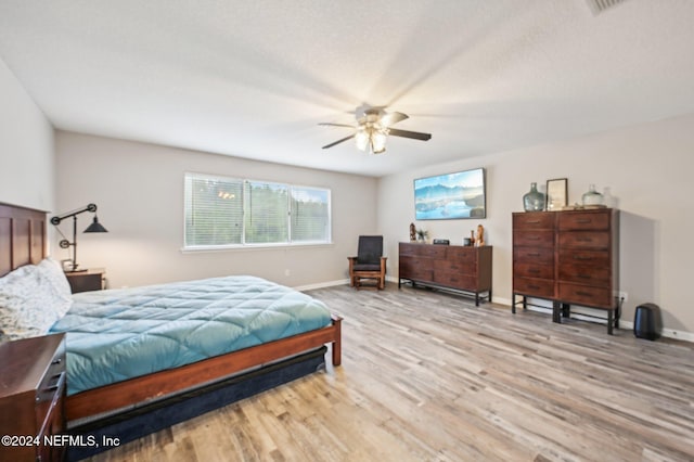 bedroom with light hardwood / wood-style floors and ceiling fan