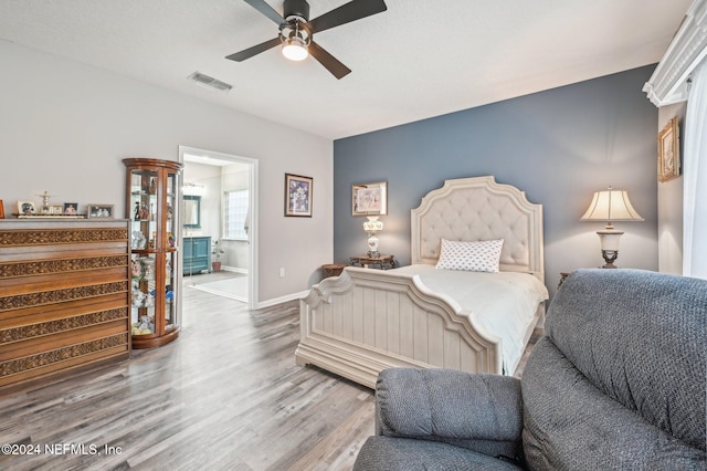 bedroom with ceiling fan, ensuite bathroom, and hardwood / wood-style floors