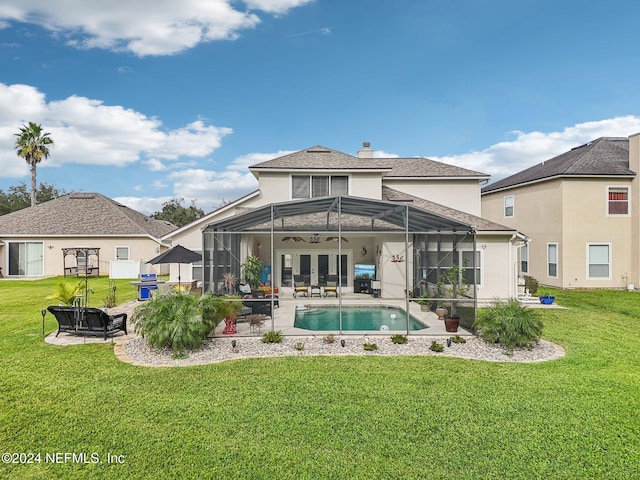 rear view of property featuring a patio, a lanai, and a yard