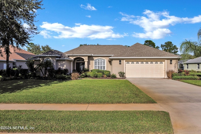 single story home with a garage and a front lawn