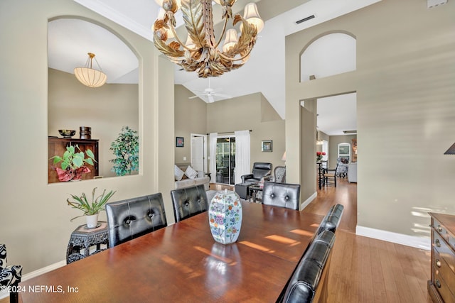 dining space with light hardwood / wood-style flooring, high vaulted ceiling, crown molding, and ceiling fan