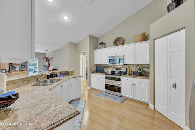 kitchen with white cabinetry, appliances with stainless steel finishes, sink, and light wood-type flooring