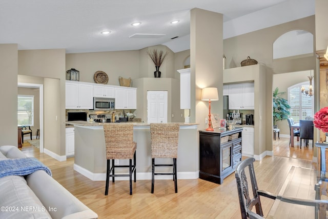 kitchen featuring a healthy amount of sunlight, a breakfast bar area, stainless steel appliances, and white cabinets