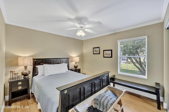 bedroom featuring ornamental molding, a textured ceiling, light hardwood / wood-style floors, and ceiling fan