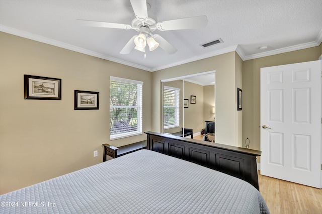 bedroom with a textured ceiling, a closet, ceiling fan, crown molding, and light hardwood / wood-style flooring