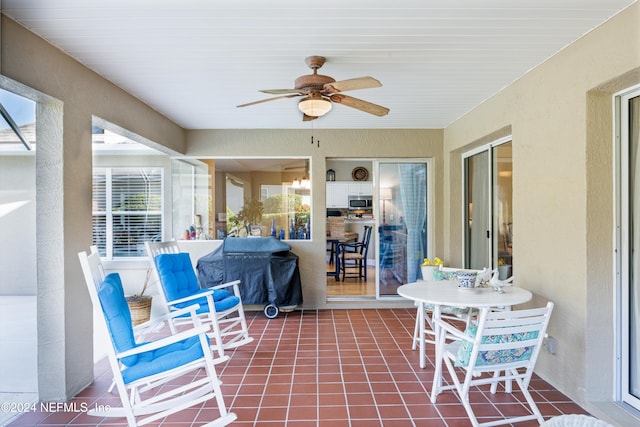 sunroom / solarium featuring a healthy amount of sunlight and ceiling fan