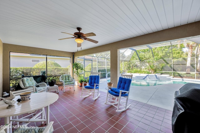 sunroom featuring a pool and ceiling fan