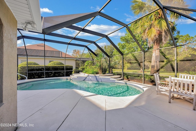 view of swimming pool with a patio area, pool water feature, and glass enclosure