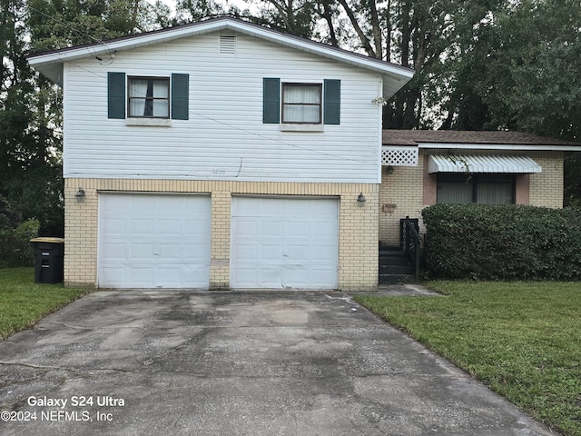 split level home with a front lawn and a garage