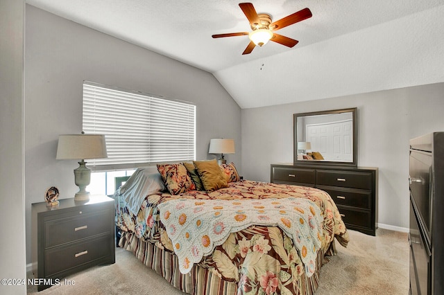 bedroom featuring vaulted ceiling, light carpet, a textured ceiling, and ceiling fan