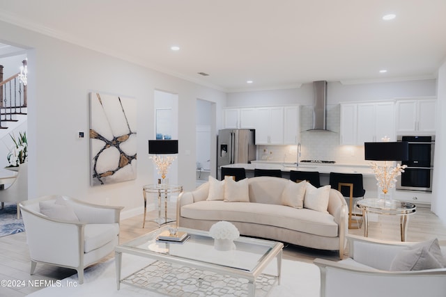 living room featuring light hardwood / wood-style floors and crown molding