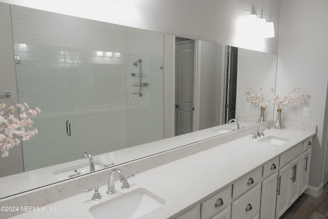 bathroom with vanity, a shower with shower door, and wood-type flooring