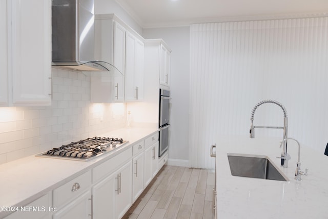 95 Caribbean Pl, Saint Johns, FL 32259 - kitchen with wall chimney range hood, appliances with stainless steel finishes, tasteful backsplash, a sink, and white cabinetry
