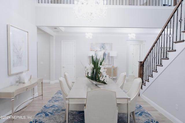 dining room with a towering ceiling and light wood-type flooring