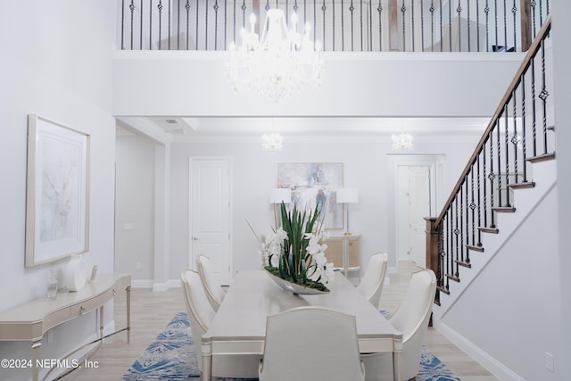 dining space with a high ceiling, light hardwood / wood-style flooring, and crown molding