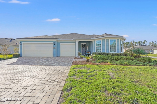 ranch-style home featuring decorative driveway and a garage