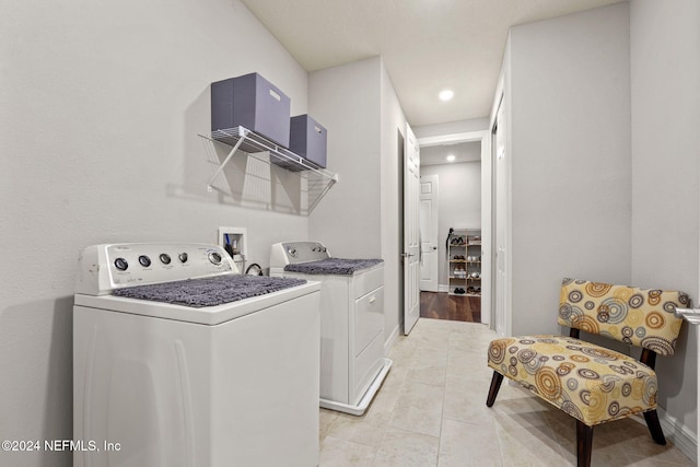 clothes washing area with light tile patterned flooring and washer and clothes dryer