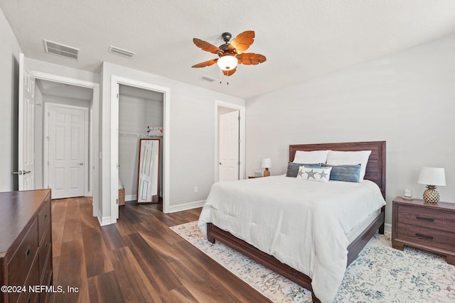 bedroom featuring a textured ceiling, ceiling fan, and dark hardwood / wood-style flooring